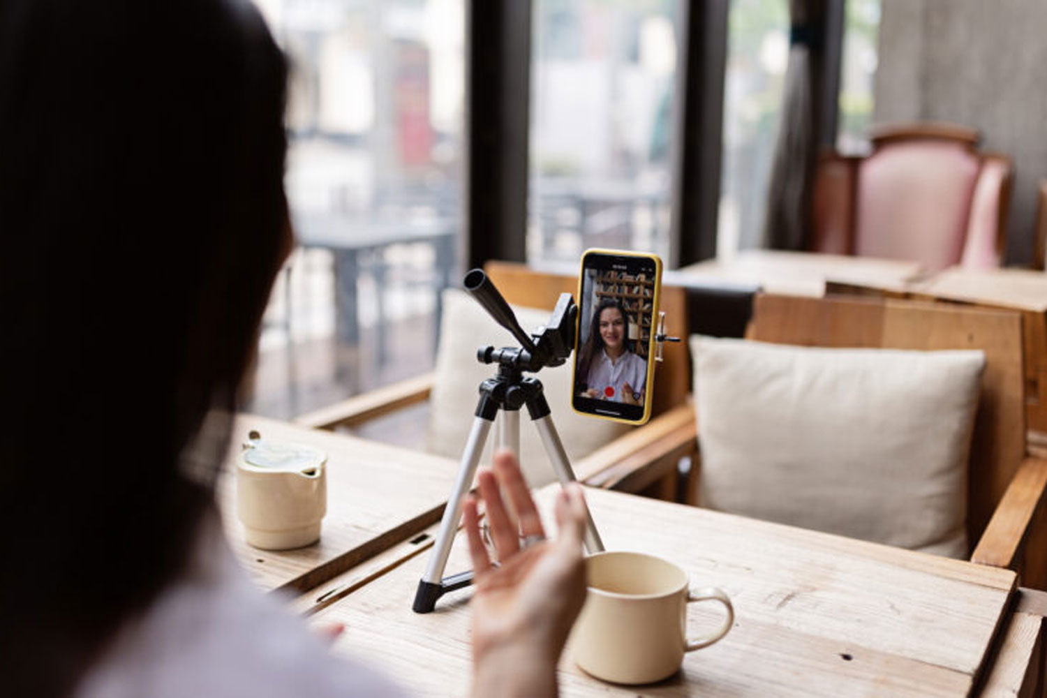 woman using iphone as camera for video of herself