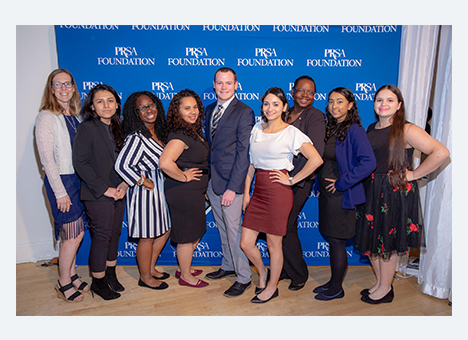 Foundation Foundation Members smiling at the camera in front of a banner that reads